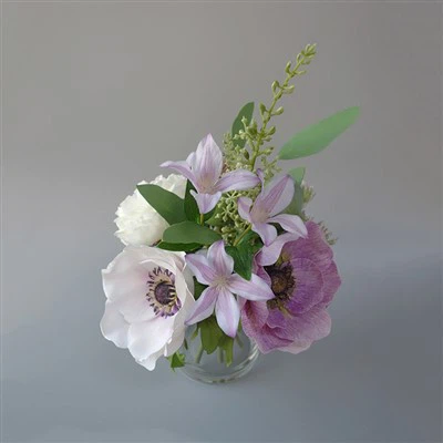 Falskt blomsterarrangemang med behållare